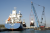 Two Cranes Work In Tandem From A Barge To Lower A U.s. Coast Guard (uscg) Patrol Boat Into The Water. Image