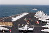 An F/a-18c  Hornet  Is Launched From The Ship S Flight Deck While Another Stands By. Image