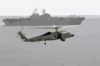 A Sh-60 Seahawk Helicopter Comes In For A Landing On The Flight Deck Of Uss Nimitz (cvn 68), While The Amphibious Assault Ship Uss Iwo Jima (lhd 7) Cruises Alongside Clip Art