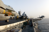 An F/a-18c Hornet, Loaded With A 500-pound Gbu-12 Laser-guided Missile, Moves Into Position While Another Launches From One Of Four Steam Powered Catapults Aboard The Uss Kitty Hawk (cv 63) Image