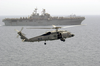 A Sh-60 Seahawk Helicopter Comes In For A Landing On The Flight Deck Of Uss Nimitz (cvn 68), While The Amphibious Assault Ship Uss Iwo Jima (lhd 7) Cruises Alongside Image